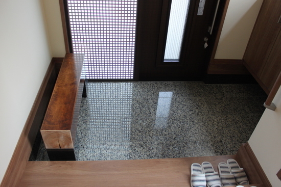 玄関土間を石張りに。大黒柱をベンチにしました。