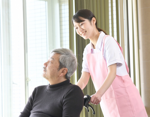 介護職員が高齢者利用者に寄り添い、笑顔でケアを行う様子