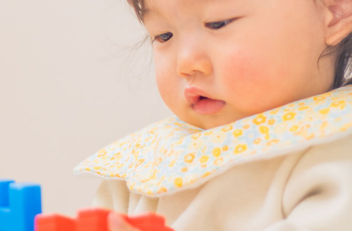 遊びに集中している幼児の口がぽかんと開いている様子