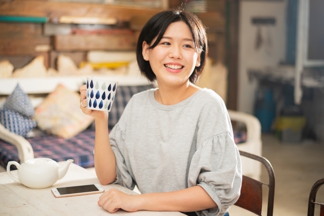 至福のひとときマグカップ持つ女性